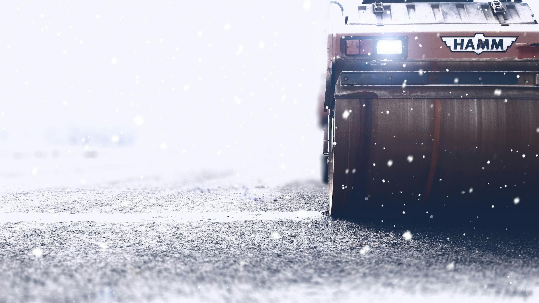 brown hamm road roller on paved road