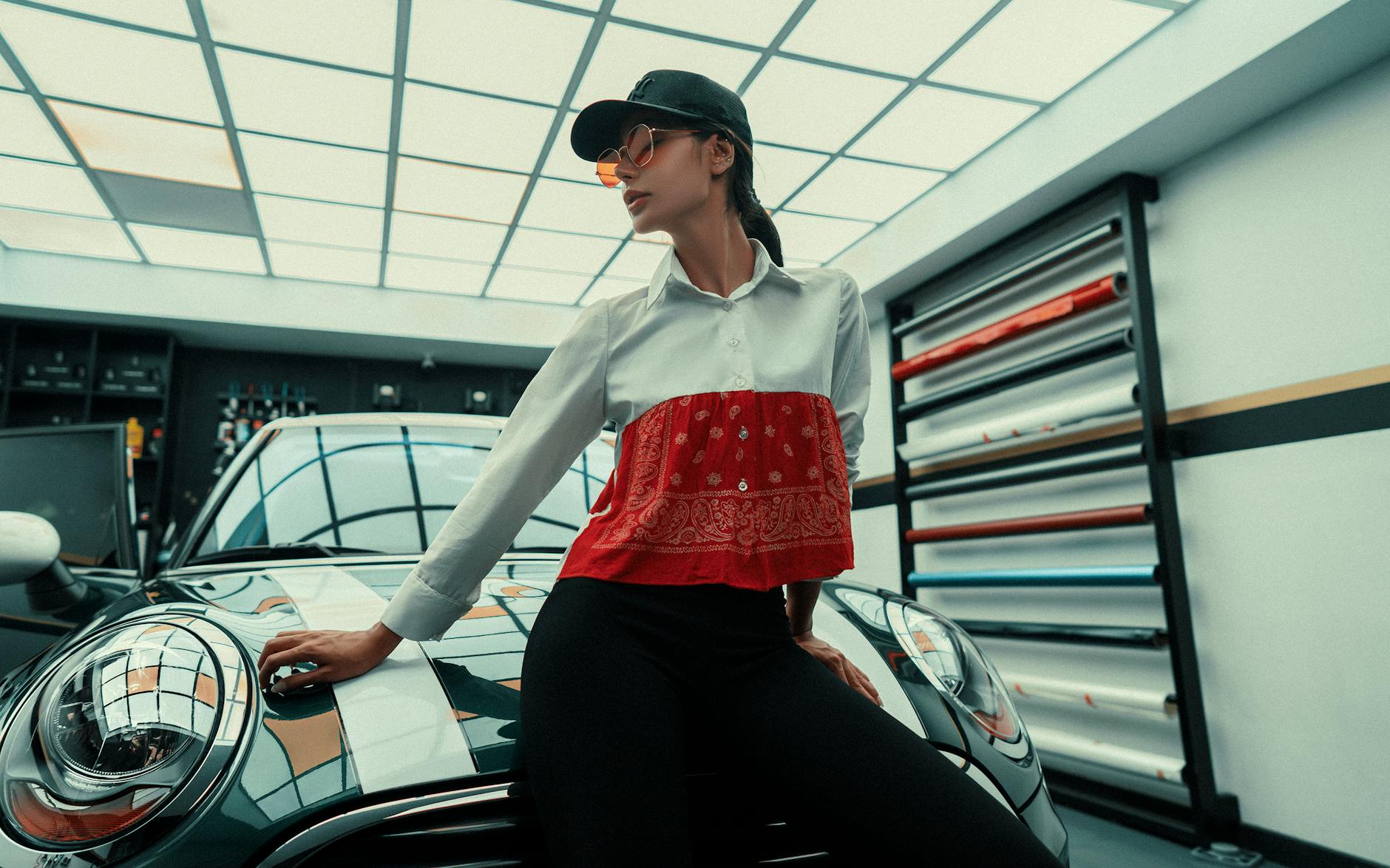 a woman sitting on the car in the garage